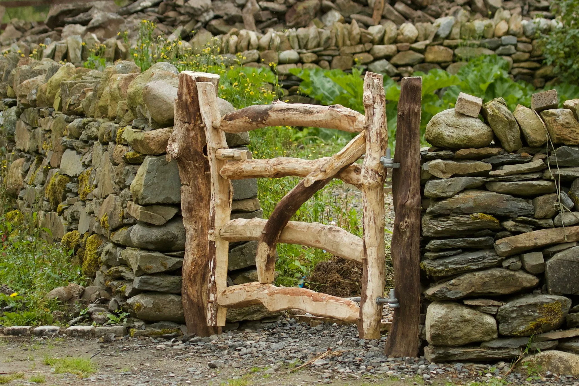 Rustic gate made of branches set in a dry stone wall